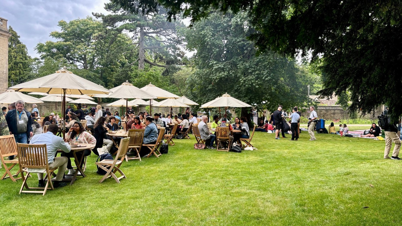 Garden party at Rhodes House with guests seated out outdoor chairs in the West Garden.