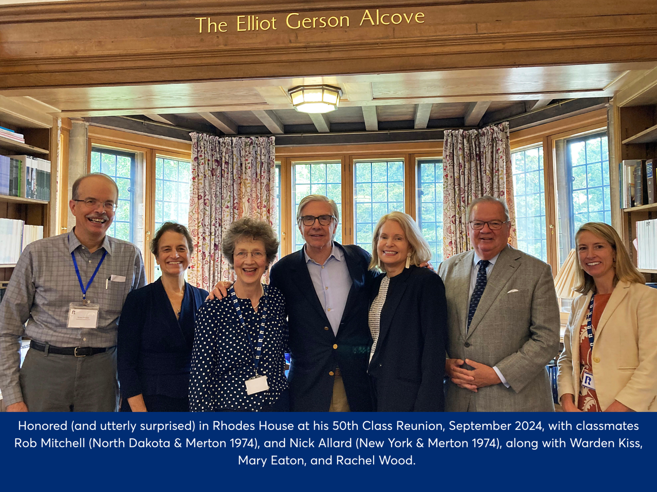 Image of Elliot in the centre of a group, standing before the 'Ellliot Gerson Alcove', a gold engraving dedicated a space in the library to Elliot. He was honoured (and utterly surprised) in Rhodes House at his 50th Class Reunion, September 2024, with classmates Rob Mitchell (North Dakota & Merton 1974), and Nick Allard (New York & Merton 1974), along with Warden Kiss, Mary Eaton, and Rachel Wood.