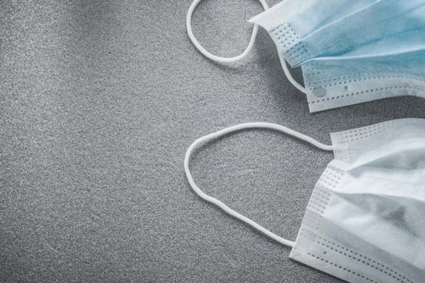 An image of two surgical facemasks laid out on a table