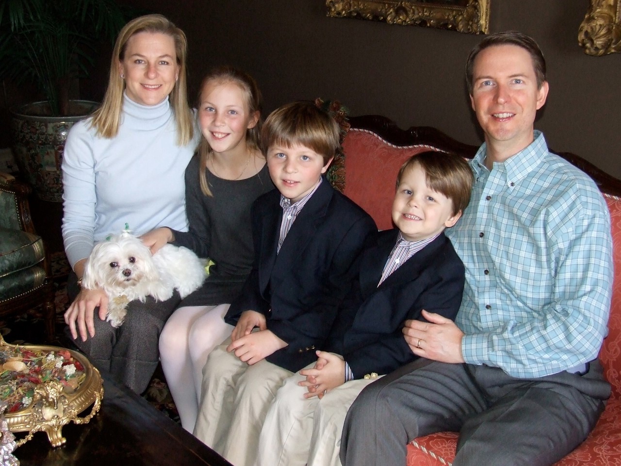 Bob seated with his wife, three children and dog on a sofa
