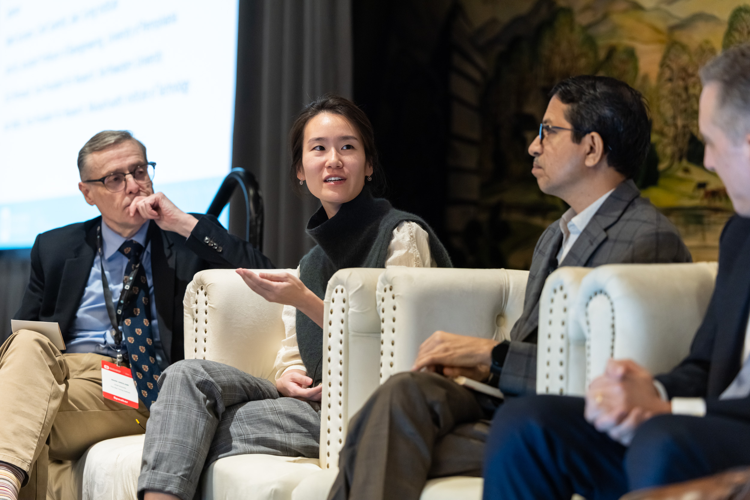 Three people in conversation, seated onstage for a panel discussion.