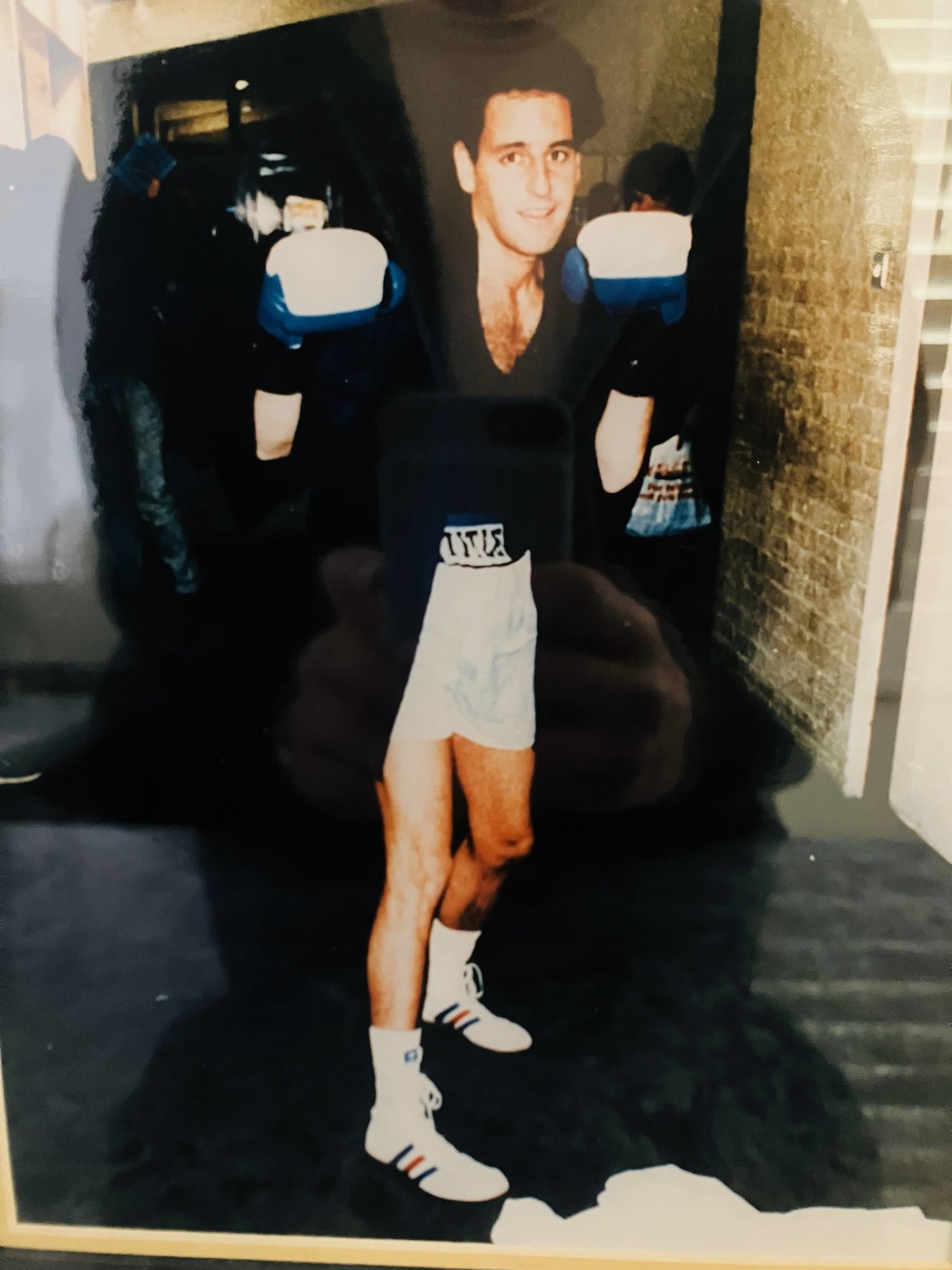 Jonathan wearing boxing clothes, gloves, robe, and posing for the camera.