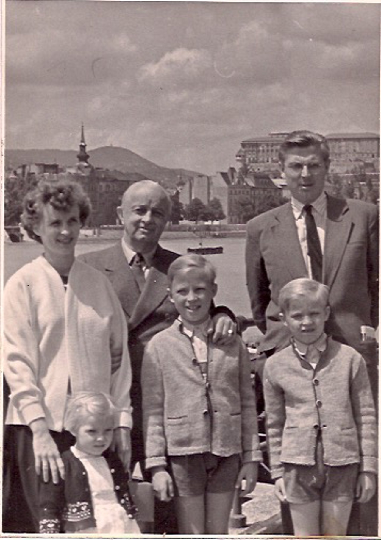 Black and white photo of Geza and his family stood in a town square, all formally posing.